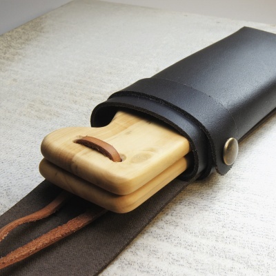 Estojo preto em couro com tábuas de madeira clara