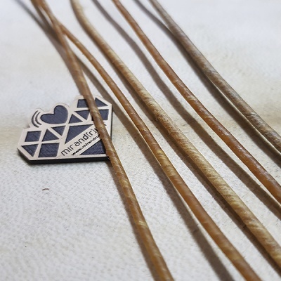 Palitos finos castanhos claros ao lado de etiqueta com texto MIRANDRE