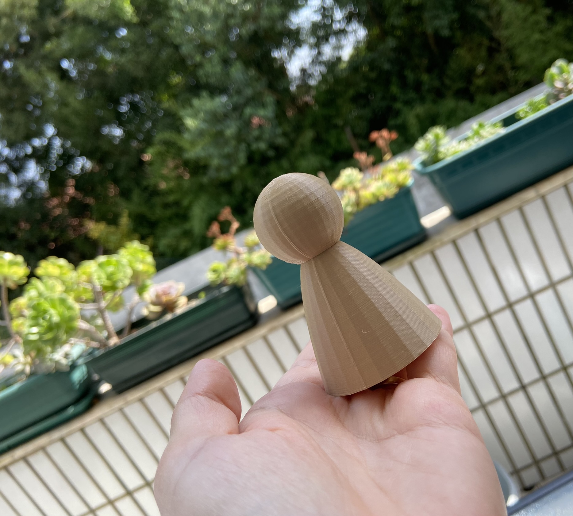 Frações # Pinos Peça de madeira clara em forma de cone com topo arredondado segurada numa mão