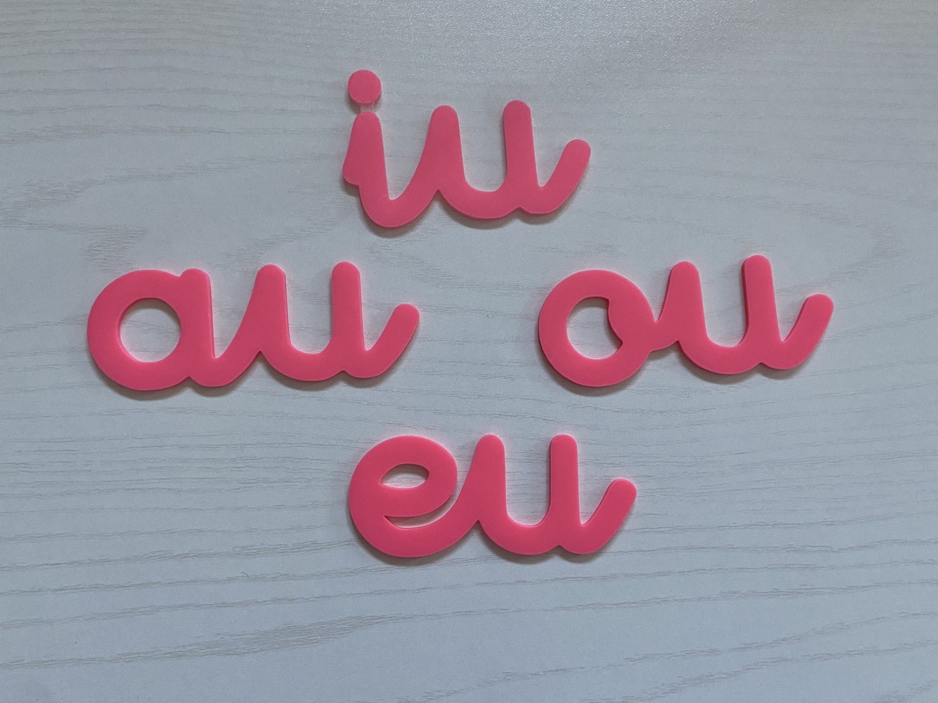 Ditongos # cor de rosa # tamanho grande Conjunto de letras em rosa sobre superfície de madeira clara