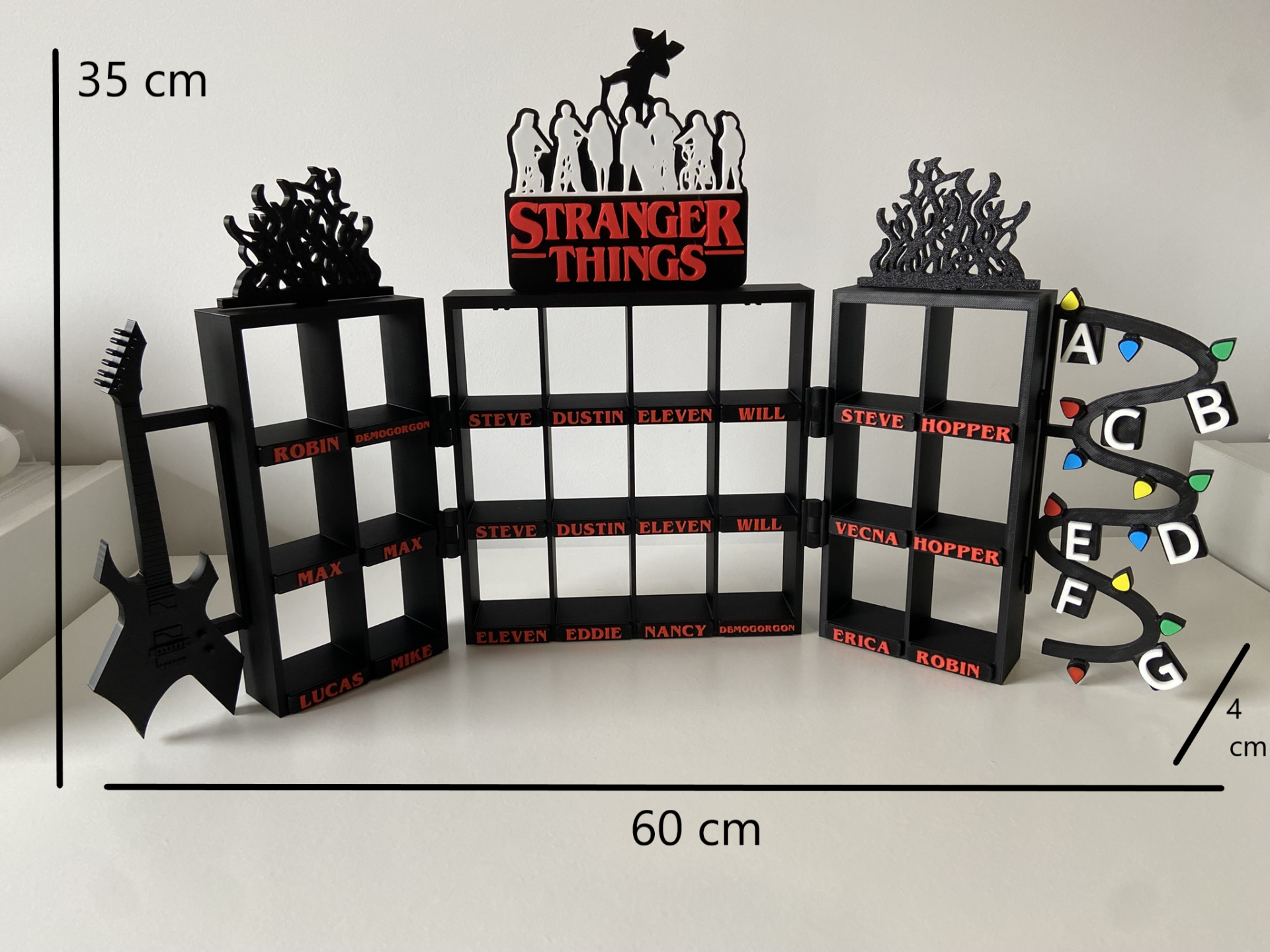 Estante exclusiva para figuras Stranger Things - Kinder Joy - Tripla - Modelo 1 Estrutura preta Stranger Things com nomes vermelhos e luzes coloridas