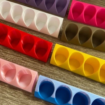 Suportes de silicone coloridos para ovos com quatro encaixes cada um sobre tecido castanho