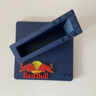 Suporte azul escuro com logótipo Red Bull e texturas tipo blocos estilo LEGO