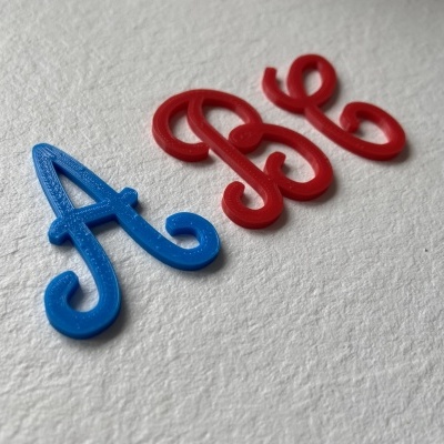 Letras decorativas azul e vermelho em superfície branca