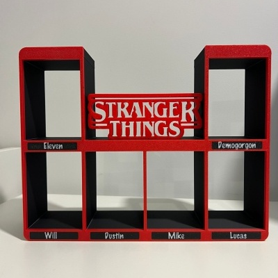 Suporte de prateleira vermelho e preto com texto Stranger Things e nomes de personagens