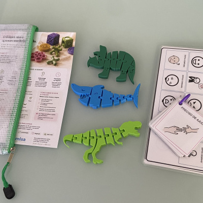 Kit de brinquedos com dinossauros e cartões de emoções em superfície cinza