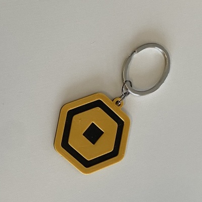 Chaveiro hexagonal amarelo com padrão preto e anel metálico