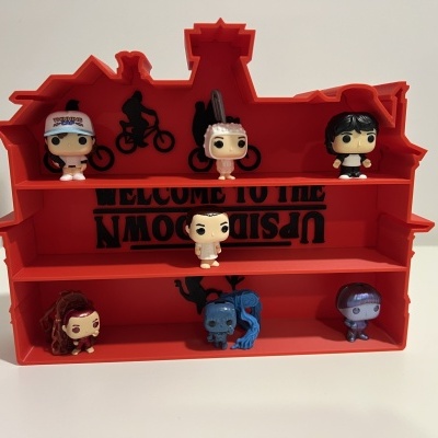 Estante vermelha forma de casa com texto e mini figuras Funko Pop