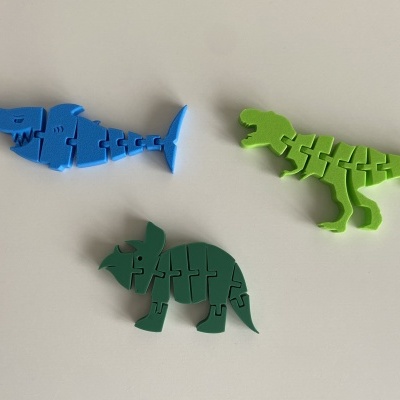 Três puzzles de madeira coloridos em forma de animais sobre fundo branco