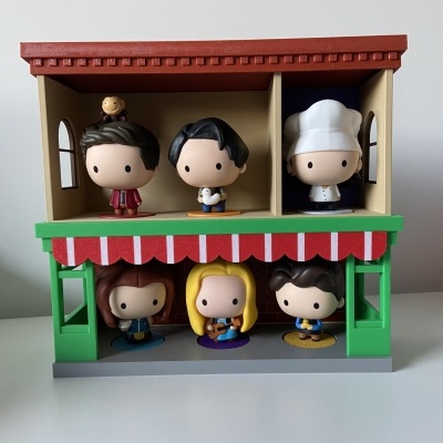 bonecos de vinil em casa plástica com telhado vermelho e toldo vermelho e branco