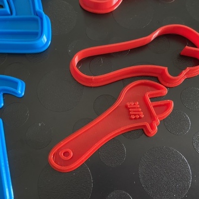 Moldes de plástico para biscoitos com formas de ferramentas sobre superfície preta