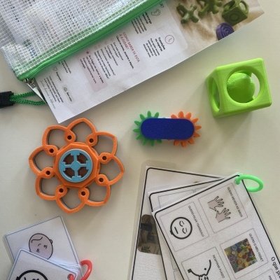 Conjunto de brinquedos educativos coloridos e cartões com pictogramas em uma mesa clara