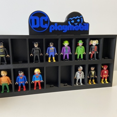 Display preto com figuras Playmobil personagens DC Comics organizadas em nichos.