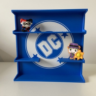 Expositor azul de plástico com logotipo DC branco e figuras Pop de Harley Quinn e Joker