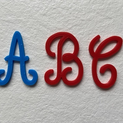 Letras decorativas A azul, B e C vermelhas em superfície branca