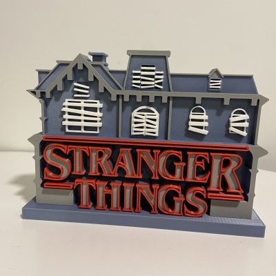 Figura decorativa Stranger Things em plástico cinzento e vermelho.