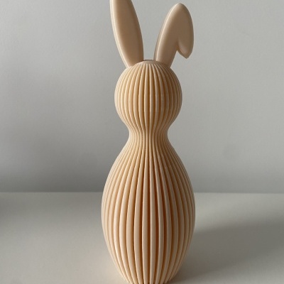 Objeto decorativo em forma de coelho creme com textura em linhas verticais