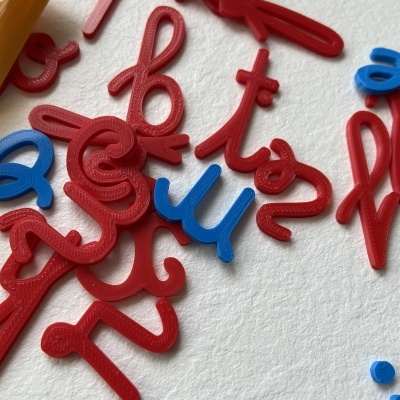 Letras de plástico vermelho e azul sobre superfície branca texturizada