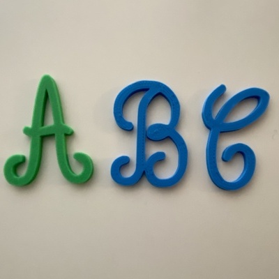 Três letras de espuma coloridas sobre fundo branco