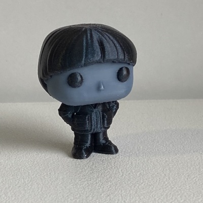 Figura colecionável pequena azul e preta com cabelo curto