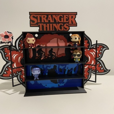 Estante preta com figuras Funko Pop Stranger Things e logo laranja e preto