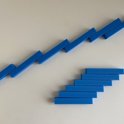 Barras azuis em plástico dispostas em zig-zag e escalão sobre superfície branca