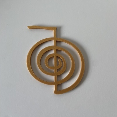 Objeto decorativo em madeira clara em forma espiralada sobre fundo branco