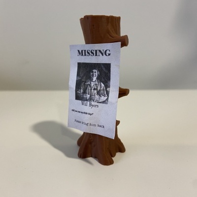 Miniatura de madeira com papel MISSING e foto preto e branco, fundo branco