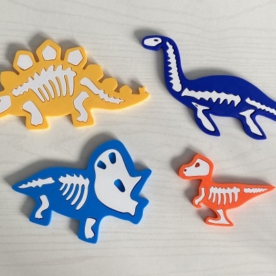 brinquedos de dinossauros em espuma colorida com esqueletos desenhados