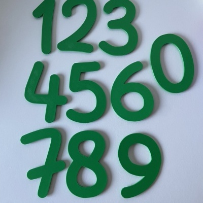 Números verdes de espuma organizados sobre superfície branca