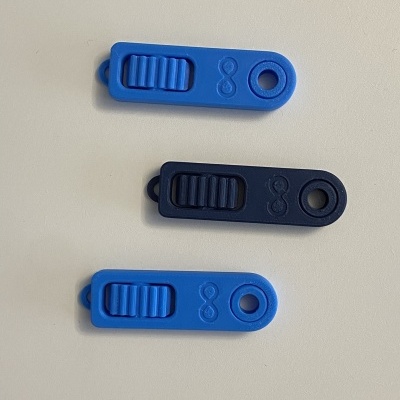 Três dispositivos deslizantes de plástico azul com orifício e padrão de infinito