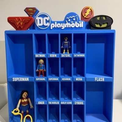 Organizador azul da Playmobil com símbolos DC e figuras Playmobil de Supergirl e Batgirl.