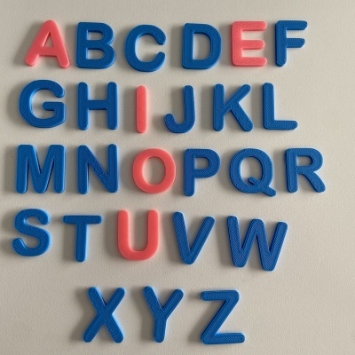 Letras plásticas coloridas do alfabeto colocadas numa superfície clara