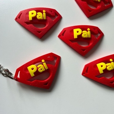 Cinco porta-chaves vermelhos em forma de escudo com a palavra Pai em amarelo