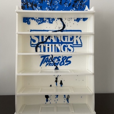 Expositor branco com design Stranger Things em fundo azul e preto