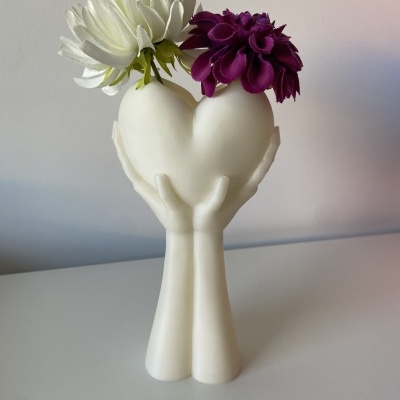 Vaso decorativo branco em forma de coração com flores branca e roxa