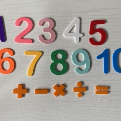 Números e símbolos matemáticos de espuma coloridos sobre fundo branco