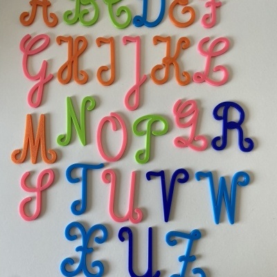 Letras coloridas do alfabeto em plástico alinhadas em fundo branco