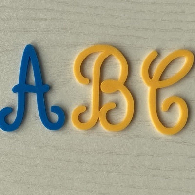 Letras plásticas coloridas A, B e C sobre madeira clara