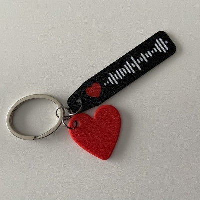 Porta-chaves com coração vermelho e pendente preto com padrão gráfico branco