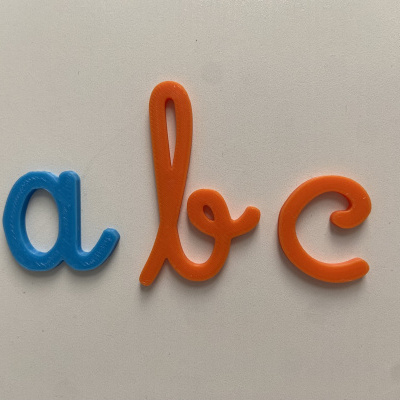 Letras de plástico coloridas azul e laranja em superfície branca