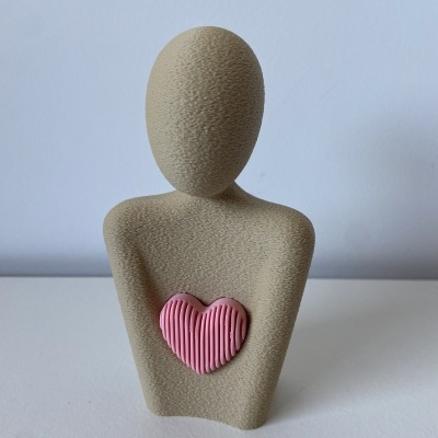 Estátua decorativa abstrata bege com coração rosa texturizado no peito
