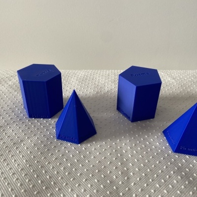 Quatro formas geométricas azuis em plástico sobre superfície texturada branca