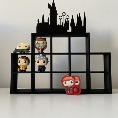 Estante preta com figuras Funko Pop e silhueta de castelo no topo