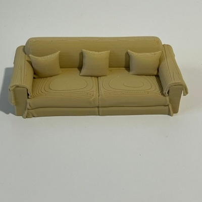 Miniatura de sofá amarelo ocre com três almofadas em fundo branco