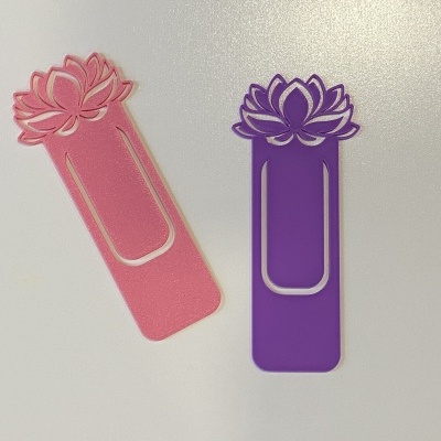 Dois marcadores de páginas de plástico rosa e roxo com design floral sobre fundo branco