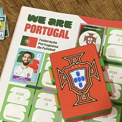 Álbum de cromos da seleção portuguesa de futebol com adesivos coloridos e caderneta com emblema da FPF