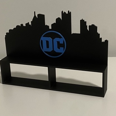 Suporte decorativo preto com skyline de cidade e logotipo DC azul