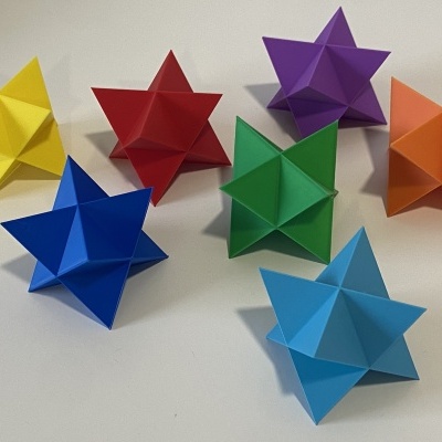 Conjunto de sete estrelas 3D de papel colorido em várias cores sobre superfície branca