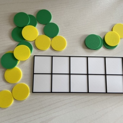 Tabuleiro retangular com 8 espaços e fichas redondas verdes e amarelas de espuma